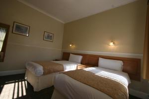 A bed or beds in a room at Grange Moor Hotel 