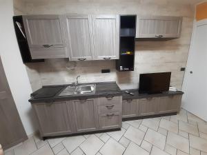 a kitchen with wooden cabinets and a sink and a tv at Casa LuLù in Catanzaro