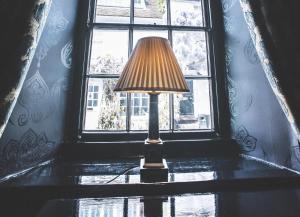 a lamp sitting on a table in front of a window at Jeakes House in Rye