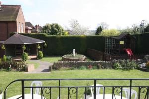 einen Garten mit einem Brunnen inmitten eines Gartens in der Unterkunft Grange Moor Hotel in Maidstone