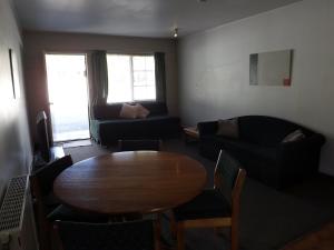 a living room with a table and a couch at Karaka Tree Motel in Taupo