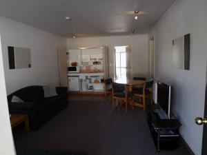 a living room with a couch and a table at Karaka Tree Motel in Taupo