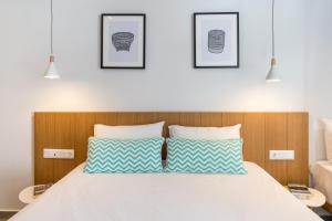 Schlafzimmer mit einem Bett mit blauen und weißen Kissen in der Unterkunft Mougre studios in Polychrono