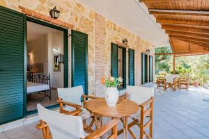 a patio with a wooden table and chairs at Giovanna Studios in Keri