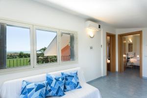 サンピエリにあるAl Ficodindiaの窓付きの客室で、白いソファ(青い枕付)