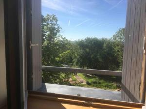 uma janela aberta com vista para um jardim em Le Dosne em Saint-Didier-sur-Arroux