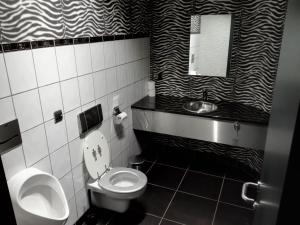 Baño en blanco y negro con aseo y lavamanos en Oxygen House, Holiday and Team building en Ovifat