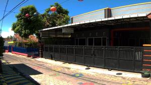 a building with a fence next to a street at Kanalan Homestay Banyuwangi in Banyuwangi