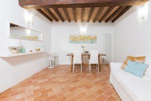 ein Wohnzimmer mit einem weißen Sofa und einem Tisch in der Unterkunft Casa Vacanze Montefalco Il Borgo in Montefalco
