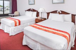 威廉斯堡的住宿－Motel Zuma，酒店客房设有两张床和窗户。