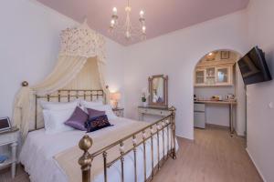 1 dormitorio con 1 cama grande y lámpara de araña en Margarita Resort en Kalamaki