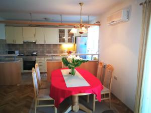 eine Küche mit einem Tisch und einem roten Tischtuch darauf in der Unterkunft Countryside Vacation House VITEZ in Babino Polje