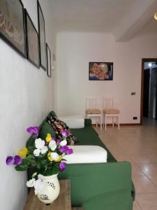 Un dormitorio con una cama verde y flores en un jarrón en Riva Trigoso Mare en Sestri Levante