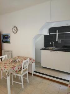 cocina con mesa, sillas y fregadero en Riva Trigoso Mare en Sestri Levante