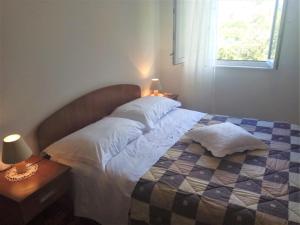 a bedroom with a bed with two pillows and a window at Countryside Vacation House VITEZ in Babino Polje