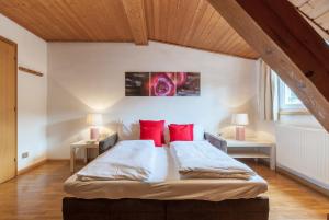 - une chambre avec un grand lit et des oreillers rouges dans l'établissement Gasthof Hanni, à Merano
