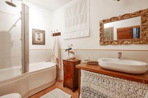 uma casa de banho com uma banheira, um lavatório e um espelho. em Il vecchio fienile em Dongo