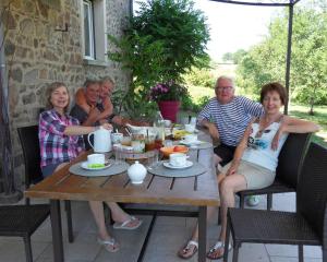 a group of people sitting around a wooden table at Aux 3 sapins in Ronno
