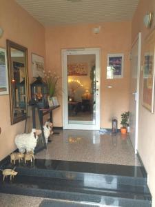 una sala de estar con dos estatuillas de oveja frente a una puerta en Hotel Am Ufer, en Trier