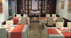 ein Restaurant mit Tischen und roten und weißen Tischen in der Unterkunft Hotel Am Ufer in Trier