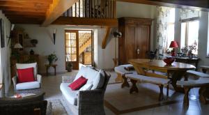 a living room with a table and a dining room at Aux 3 sapins in Ronno