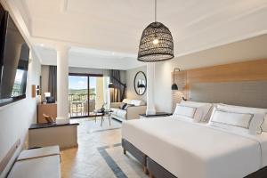 a bedroom with a large bed and a living room at Melia Villaitana in Benidorm