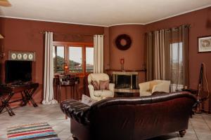 a living room with a leather couch and chairs at Villa Loridis in Prinos