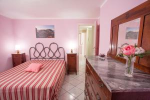 una camera da letto con un letto e un vaso di fiori su un bancone di Casa Malva a Portoferraio