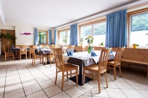 - une salle à manger avec des tables, des chaises et des fenêtres dans l'établissement Gasthof Steg, à Campodazzo