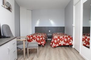 - une chambre avec 2 lits, une table et des chaises dans l'établissement LES TERRASSES DE BORDA***, à Dax
