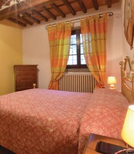 1 dormitorio con 1 cama con cortinas de color naranja y ventana en Casa Marianna, en Lucca