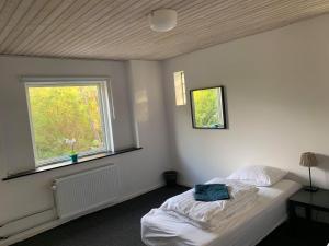 1 dormitorio con cama blanca y ventana en Second home, en Herlev