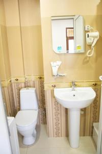 a bathroom with a white toilet and a sink at Apartments Of Aurumi in Tbilisi City +30 photos