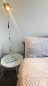 una cama y una mesa con una lámpara junto a una cama en Cambridge City Studio en Cambridge
