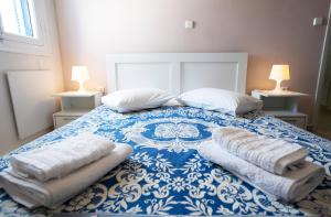 a bedroom with a blue and white bed with two pillows at Spacious Villa with private garden and BBQ in Spetses