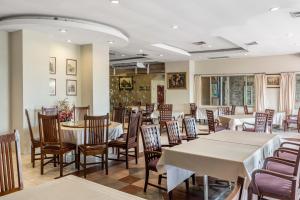 uma sala de jantar com mesas e cadeiras num restaurante em Ayothaya Riverside Hotel em Phra Nakhon Si Ayutthaya