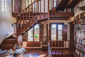 een houten trap in een bibliotheek met boeken bij Iconic Cretan Stone Mansion in Kambánion