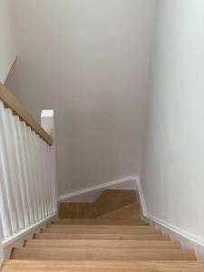a staircase with white walls and wooden floors at Primrose Place Portrush in Portrush