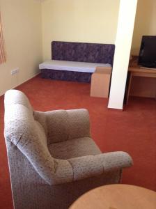 ein Wohnzimmer mit einem Stuhl und einem Bett in der Unterkunft Hotel YORK in Pilsen