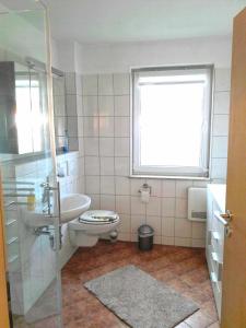 ein Bad mit einem WC, einem Waschbecken und einem Fenster in der Unterkunft Apartment Neptun in Ückeritz