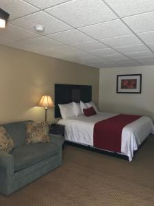 a hotel room with a bed and a couch at Brentwood Motor Inn in Marquette
