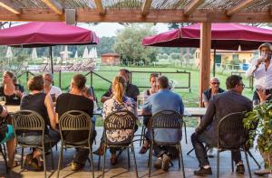 a group of people sitting at a table under umbrellas at La Fattoria di Tirrenia in Tirrenia