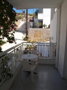 a balcony with a table and chairs on a balcony at Roses Studios in Karpathos