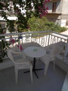 a white table and two chairs on a balcony at Roses Studios in Karpathos