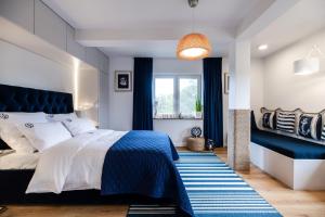 a bedroom with a blue and white bed and a window at Niebieskie Apartamenty Rowy Apartament z klimatyzacją 100 m do plaży in Rowy
