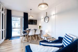a living room with a blue couch and a table at Niebieskie Apartamenty Rowy Apartament z klimatyzacją 100 m do plaży in Rowy