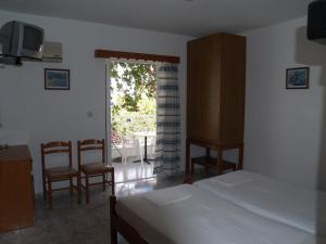a bedroom with a bed and a table and chairs at Roses Studios in Karpathos