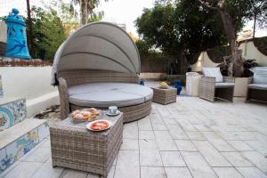un patio con tavolo, sedie e letto di Oasi Relax Manzoni by HHN a Napoli