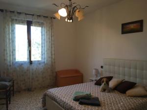 a bedroom with a bed with a teddy bear sitting on it at La casina nel Borgo in Cetona