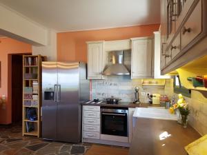 uma cozinha com armários brancos e um frigorífico de aço inoxidável em Hand Crafted with sea View em Caristo